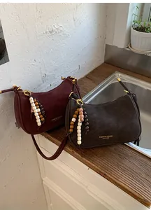 Vue détaillée des sacs portés épaule en cuir mat rétro avec breloques en perles ethniques