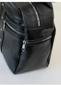 Detailed close-up of premium black PU leather texture and silver metal zippers on the bag