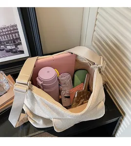 Detail view of a beige corduroy tote bag showing large capacity for tablets and bottles