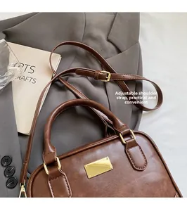 Detail of vintage brown leather bowling bag with gold hardware and adjustable strap
