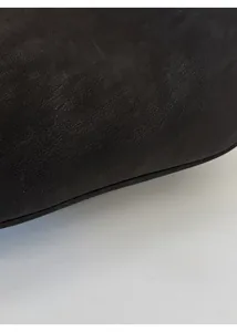 Détail du cuir noir grainé avec marquage à l'or et texture de qualité supérieure du sac