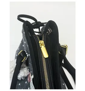Detailed close-up of premium gold zipper and polka dot fabric on large tote bag
