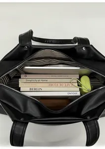Top view of large black leather tote bag with striped lining showing spacious interior