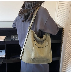 Detail of green corduroy tote bag showing ribbed texture and metal adjustable buckle