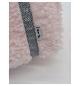 Close-up of pink faux fur plush material with a chiccraze woven label on a stylish bag
