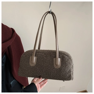 Detail of dark brown plush tote bag showing soft faux shearling texture and leather strap