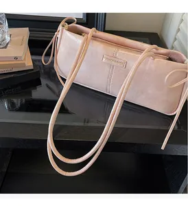 Detail of pink bow shoulder bag with textured leather and Fashion & Bags logo