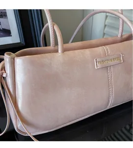 Detail of pink faux leather texture and stitching on minimalist women's baguette bag