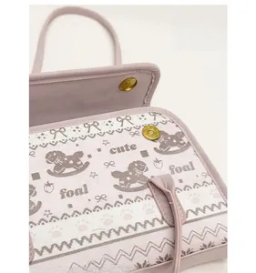 Detail of light purple tote bag featuring a magnetic snap closure and cute pony print