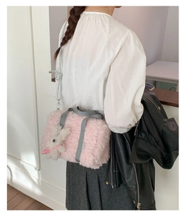 Detail of pink plush pillow bag with grey canvas handles and a white rabbit charm