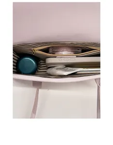 Interior view of the pink shoulder bag showing large capacity and striped fabric lining
