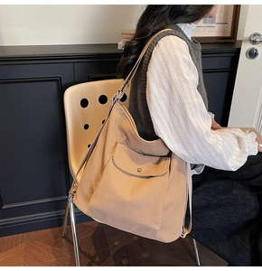 Detail of corduroy tote bag with front pocket and adjustable strap on a shoulder