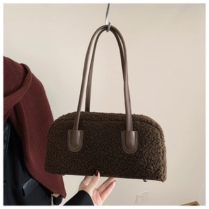 Close-up of brown teddy faux fur texture and leather handle on a chic shoulder bag