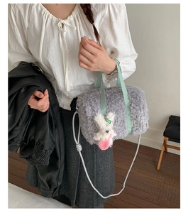 Detail of grey plush square bag with green strap and cute white bunny charm