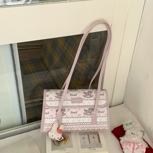 Detail of light purple canvas shoulder bag featuring pony prints and a plush bunny charm