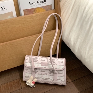 Detail of pink striped shoulder bag with foal print and cute rabbit pendant in cozy setting