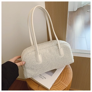 Detail of soft cream faux shearling texture on shoulder bag with leather handle
