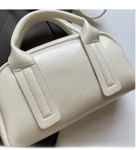 Détail du sac Boston crème montrant le grain du cuir et les finitions de couture