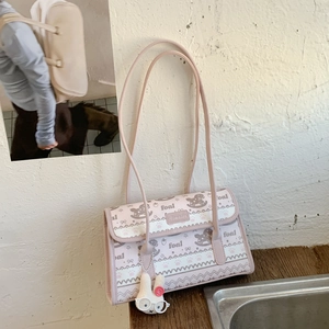 Detail of light pink shoulder bag with foal patterns and white rabbit plush charm