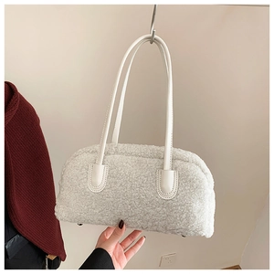 Detailed view of the plush white faux fur handbag texture with sleek leather straps
