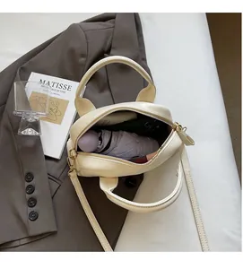 Vue de dessus du mini sac boston crème montrant l'espace intérieur pour smartphone