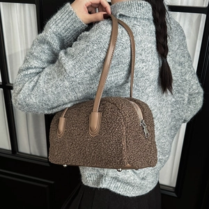 Detailed view of brown teddy fur shoulder bag with leather handles and silver zipper