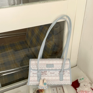 Detail of blue striped shoulder bag featuring foal patterns and a cute rabbit plush charm