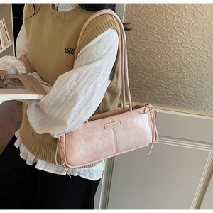 Detail of pink baguette bag with side bow accents and metallic fashion label decoration