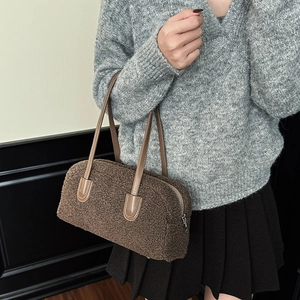 Macro detail of plush teddy fleece texture and leather strap on vintage boston bag