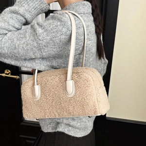 Detailed close-up of fluffy beige faux fur shoulder bag with cream leather straps