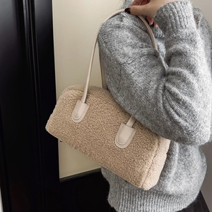 Detail of soft cream faux shearling texture and leather strap on a shoulder bag
