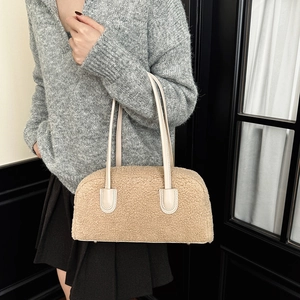 Detail of beige fleece underarm bag with smooth leather handles and soft plush texture