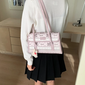 Detail of pink shoulder bag featuring horse prints and a white rabbit plush keychain