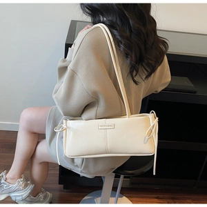 Minimalist beige baguette bag shown on shoulder for daily commute style and fit
