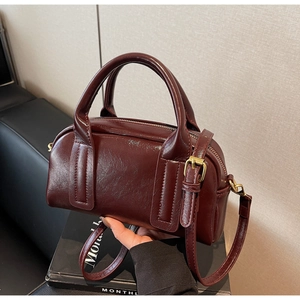 Détail du sac Boston bordeaux montrant la texture cuir huilé et boucles vintage