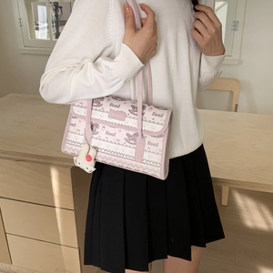 Detail of light pink shoulder bag with cartoon foal prints and plush charm pendant