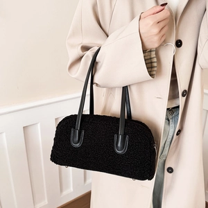 Detail of the soft black plush fleece texture and leather straps on this shoulder bag