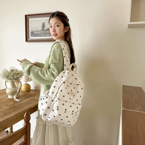 Floral print white backpack detail with large main compartment and front zipper pocket