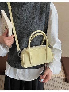 Pale yellow matte leather bowling bag shown with detachable strap and top handles