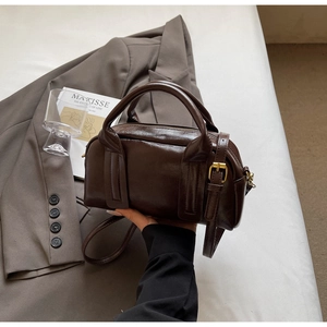 Détail du sac Boston vintage en cuir marron foncé avec bandoulière à boucle métallique réglable