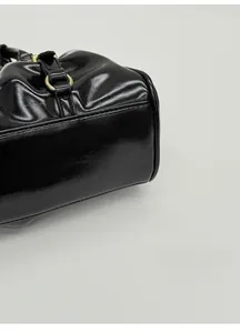 Detail shot of the wide base design on a glossy black handbag for better stability