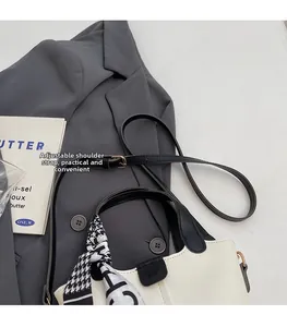 Detail of white leather bucket bag with adjustable strap and chic houndstooth silk scarf