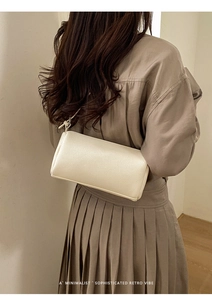 Minimalist beige textured leather baguette bag shown as a stylish underarm shoulder bag