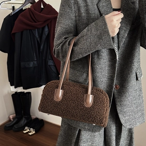 Detail of dark brown shearling texture with leather handles on a stylish shoulder bag