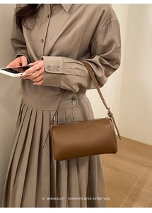 Close-up of brown Boston cylinder shoulder bag with lychee grain texture and silver buckle