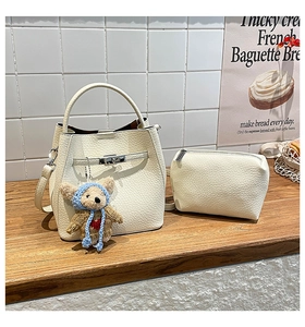 Detail of white litchi pattern bucket bag with bear charm and matching pouch