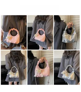 Détail de sacs à poignée nuage rose et argent avec breloques perles et nœuds sur chaîne
