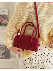 Detail of red Boston crossbody bag with dual handles and matte faux leather texture