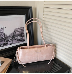 Detail of pink baguette shoulder bag with retro texture and fashion metal plaque