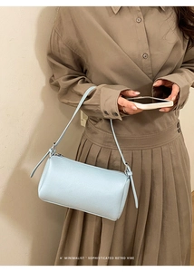 Macro shot of light blue lychee pattern leather shoulder bag with sleek metal zipper